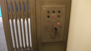 エレベーター1号機の階数パネル。左はじゃばら風の扉。